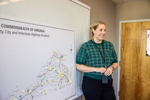 Person in green, plaid shirt standing at a whiteboard giving a presentation